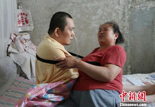 身體日漸衰老的梁青蘭每次幫兒子翻身、坐立，全身的衣物都要濕透一次?！∩忻鱾b 攝