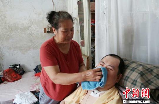 每次喂完食物后，梁青蘭都要仔細(xì)地幫兒子清理干凈?！∩忻鱾b 攝