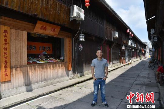 圖為:“誠(chéng)信小賣(mài)部”的店主王金偉 范宇斌 攝