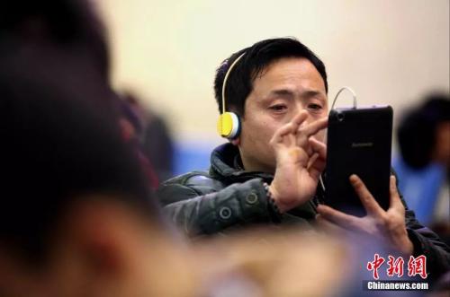 資料圖：候車室內(nèi)，玩手機(jī)的&ldquo;低頭族&rdquo;隨處可見(jiàn)。刷微博、聊微信、玩游戲、看電影，高科技將大多旅客變?yōu)槭謾C(jī)&ldquo;低頭族&rdquo;。<a target='_blank' ><p  align=